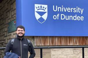 Dener Silva Miranda em frente ao logotipo da Universidade de Dundee, na Escócia, onde ele estudou pelo programa Ciência Sem Fronteiras (Foto: Reprodução)