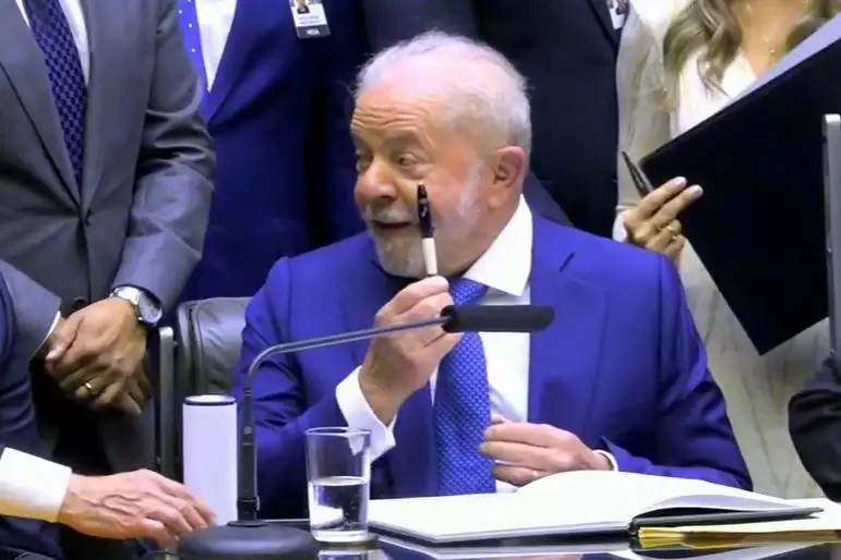 Lula segurando a caneta durante posse