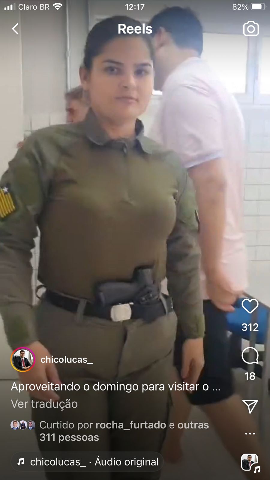 Policial fardada recepcionando o secretário que usa chinela e bermuda