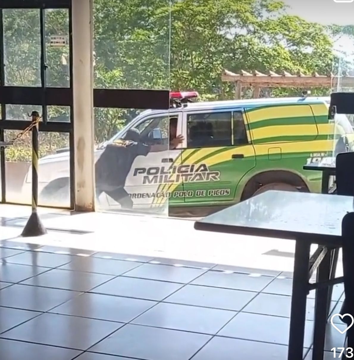 A segurança pública para chinês ver: por mais que queira e faça força o policial não consegue mover a viatura que está no prego na frente de um restaurante