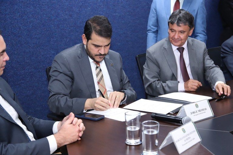 O advogado-geral da União, Jorge Messias, assina acordo ao lado do ministro do Desenvolvimento Social, Wellington Dias