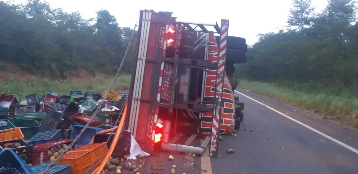 Caminhão carregado de frutas tomba e deixa o motorista ferido