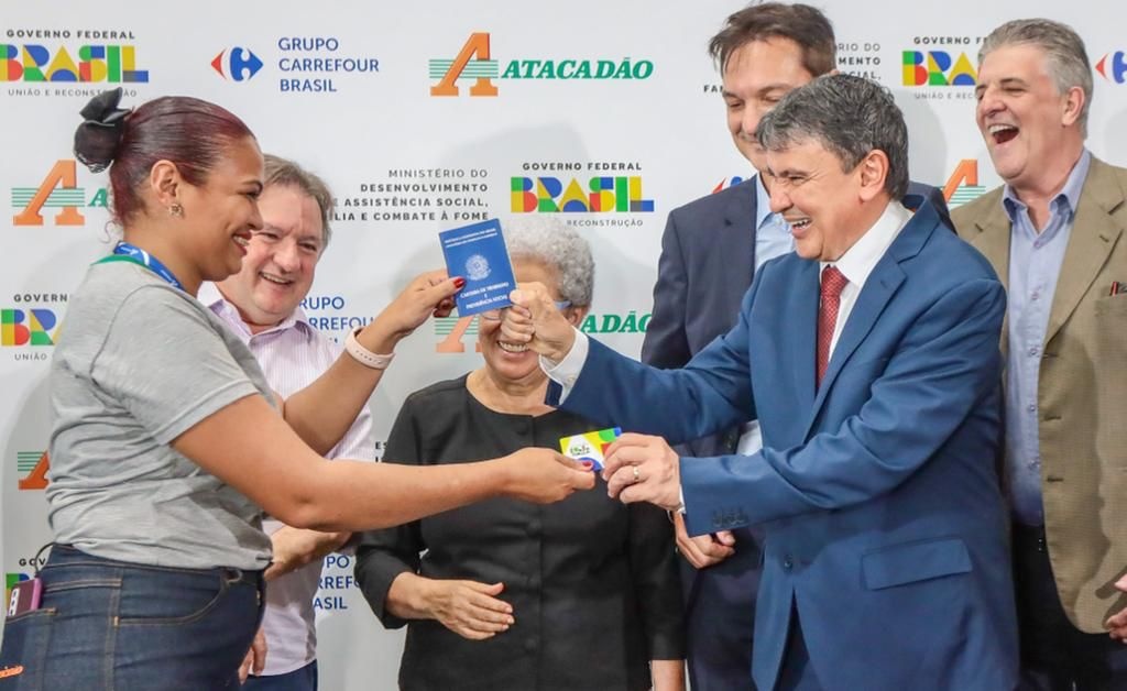 Ministro Wellington Dias recebendo o cartão do Bolsa Família e entregando carteira de Trabalho