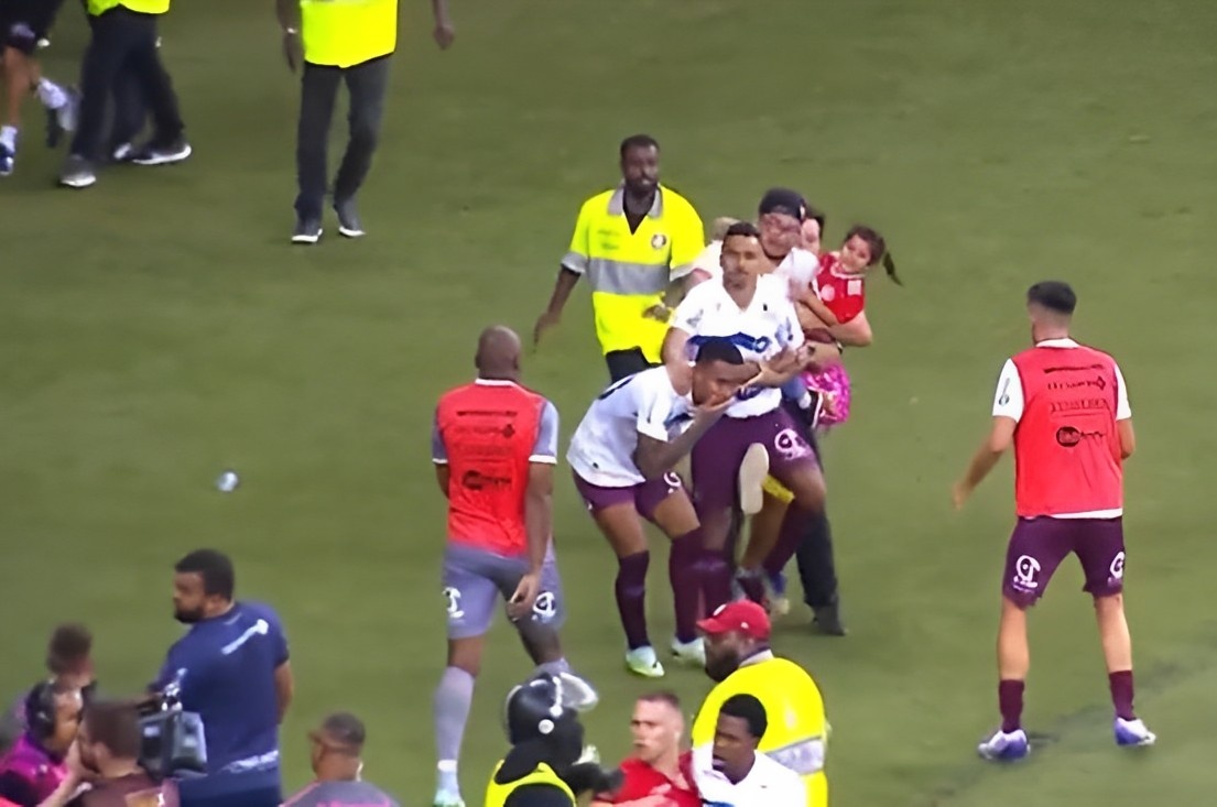 Torcedor com criança no colo invandiu o campo e chutou um jogador