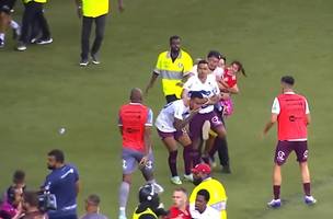 Torcedor com criança no colo invandiu o campo e chutou um jogador (Foto: Reprodução)