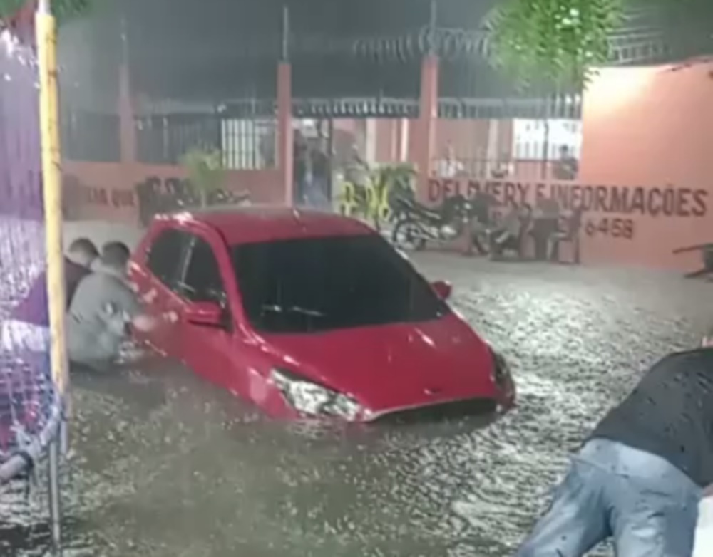 Homens tentam segurar veículo sendo arrastado pela correnteza