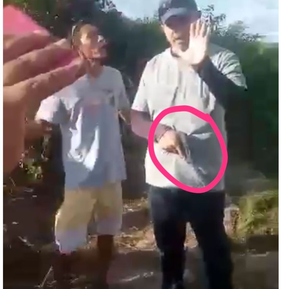 Um homem aparece armado e é cercado pelos moradores que pedem que ele jogue a arma no chão