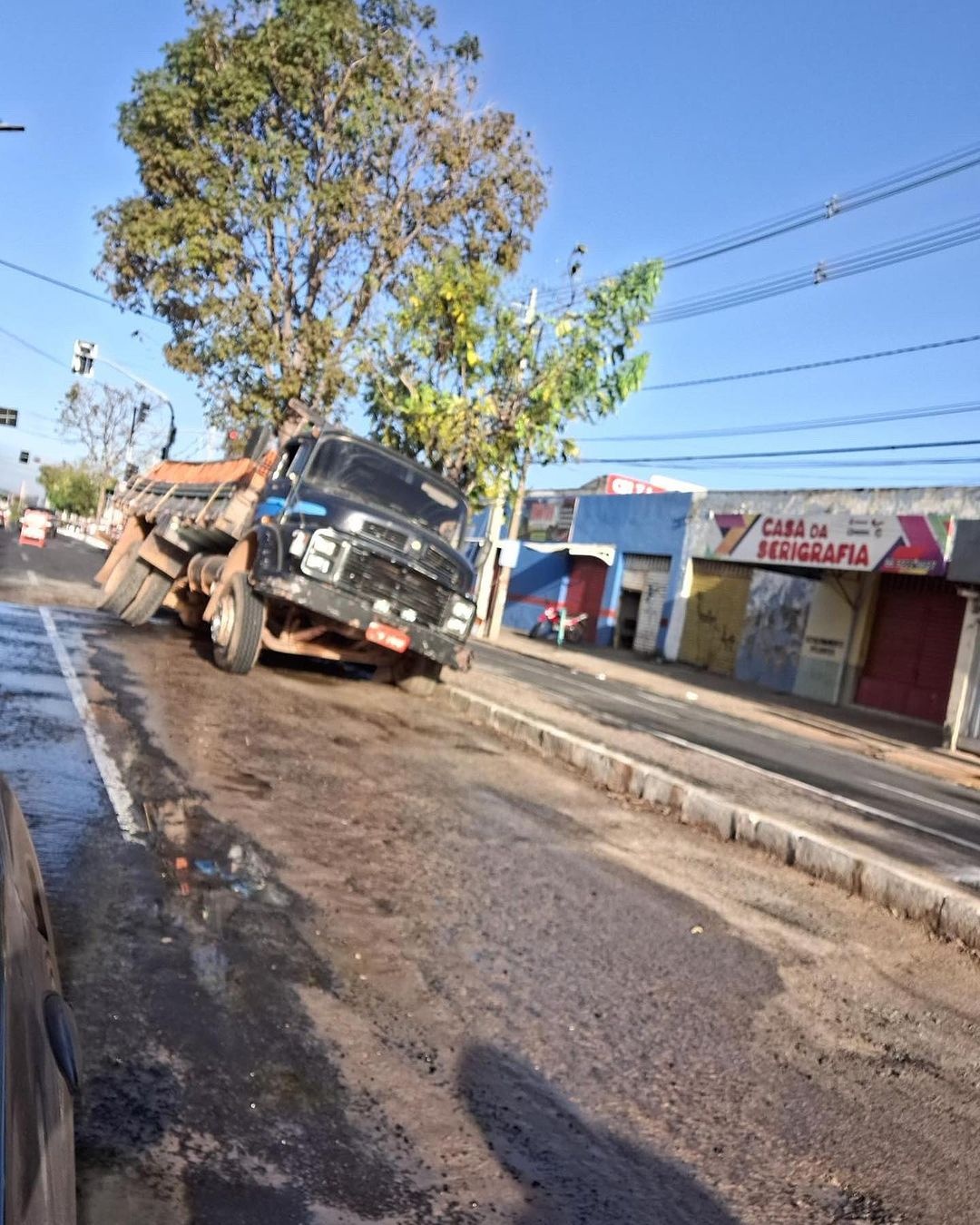 O caminhão ficou preso na cratera que se avriu na via
