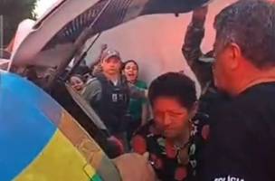 A mulher foi levada pelos policiais sob gritos da população ao redor (Foto: Reprodução)