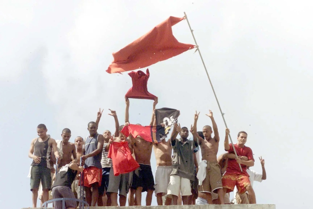 Brasil, Rio de Janeiro, RJ, 19/04/2002 Rebelião de presos na Casa de Custódia Jorge Sant'ana, em Bangu. Presos no telhado fazendo agito com a bandeira da facção Comando Vermelho (CV)