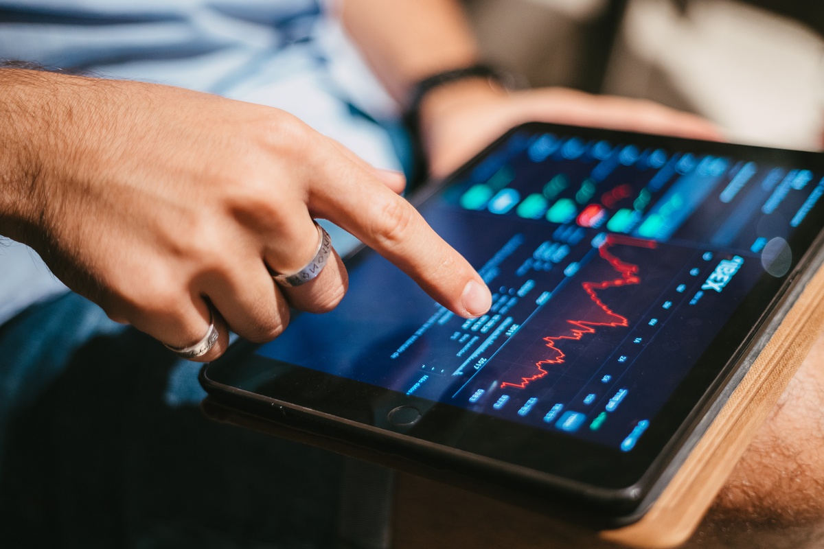 Homem a verificar dados do mercado de ações no tablet