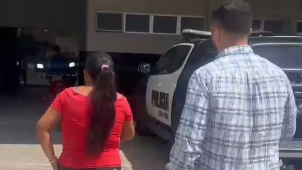 Momento que a mulher é conduzida à delegacia