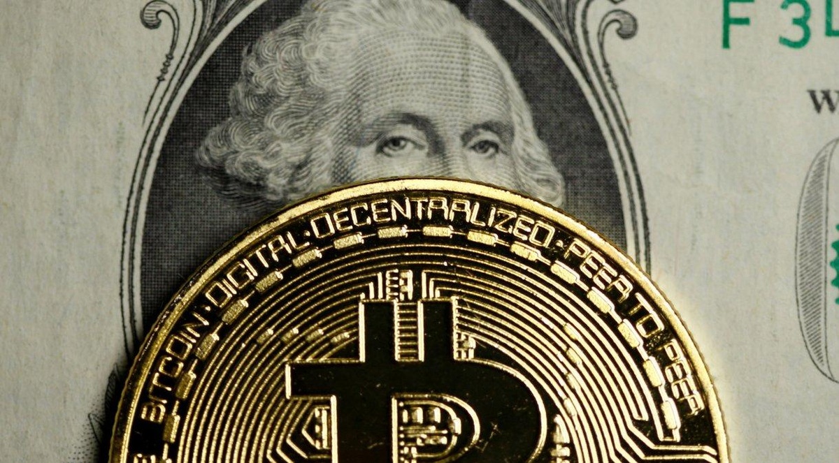 Representação do Bitcoin em cima de uma nota de dólar em foto de ilustração• 27/09/2017 REUTERS/Dado Ruvic