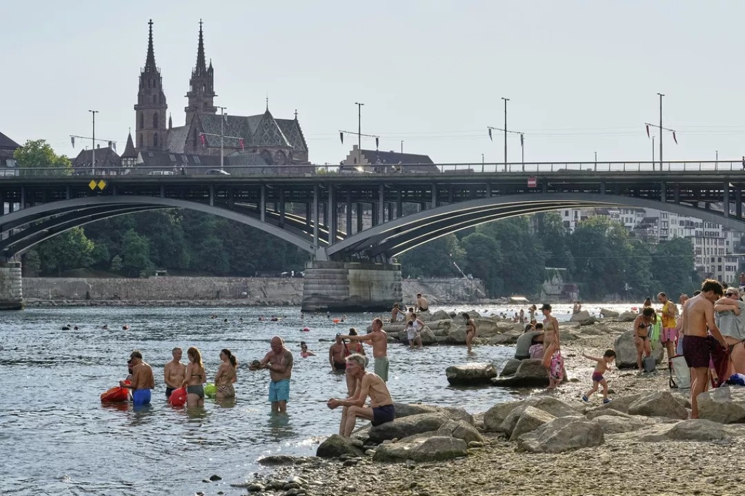 Pessoas refrescam-se no rio Reno durante uma onda de calor no centro da cidade de Basileia, na Suíça, segunda-feira, 30 de junho de 2025.