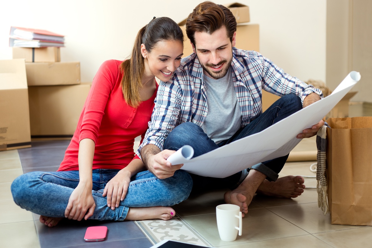 Um jovem casal olhando para os planos de sua nova casa