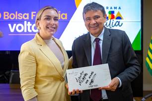 Amiga de Lulinha, a empresária Roberta Luchsinger entrega livro autografado por Paulo Coelho ao ministro do Desenvolvimento Social, Wellington Dias.