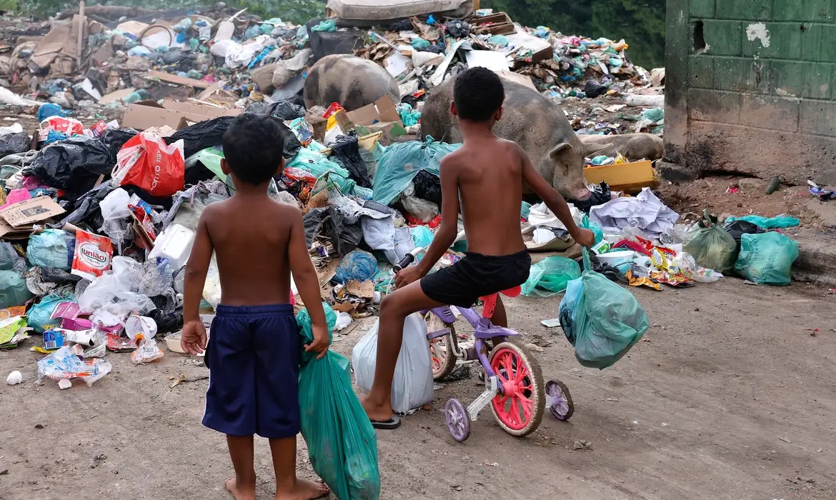 Crianças brincam em área próxima à Baía de Guanabara, no Rio de Janeiro.